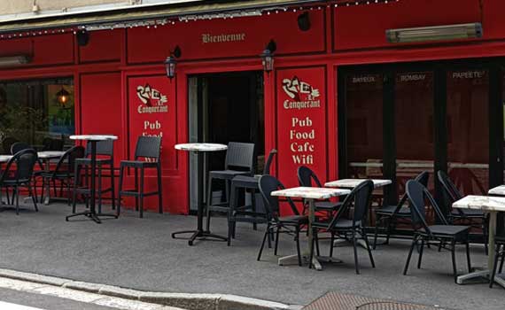 Façade rouge de la brasserie, tables et chaises